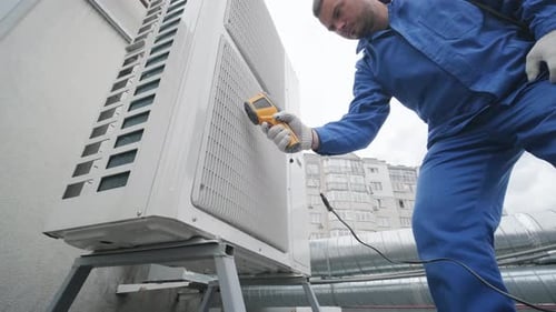 Man Inspecting Air Conditioning Unit with Scanner