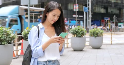 Young Woman Using Phone in City Street