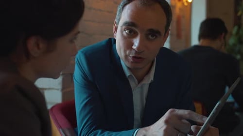 Business Partners Discuss the Contract in Cafe