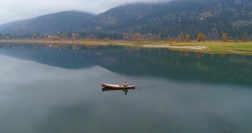Man rowing boat with his dog on a lake