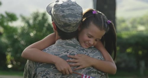 Child Hugs Military Member in the Park