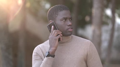 Young man using smart phone in public park