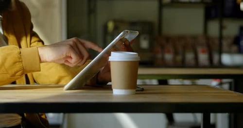 Mid section mixed-race man using digital tablet in cafe 4k
