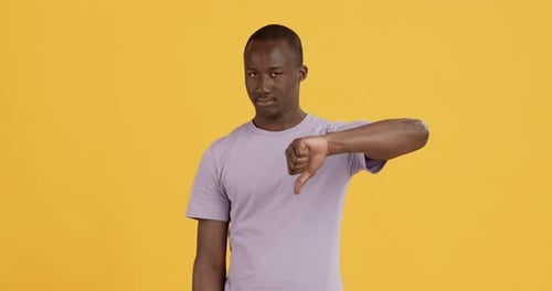 Grumpy African American Guy Showing Thumb Down Gesture