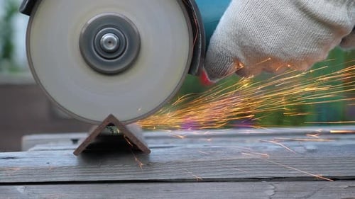 Worker in Gloves Use Angle Grinder