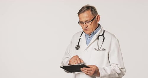 Man in Lab Coat Using Tablet