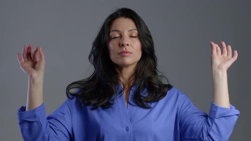 Woman with Eyes Closed Meditating with Hands Raised