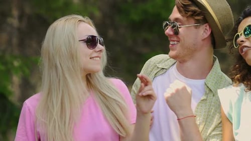 Cheerful Friends Dancing Together Outdoors in Sunny Park