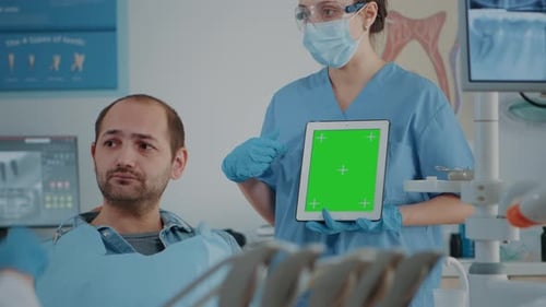 Stomatology Nurse Vertically Holding Tablet with Green Screen