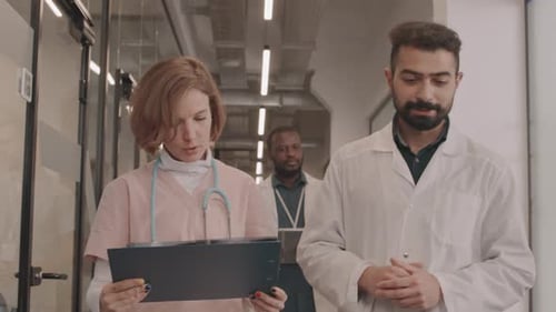 Medical Team Walking through Hospital Corridor