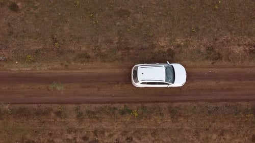Une caméra prend une vue aérienne d'une voiture en mouvement dans la steppe