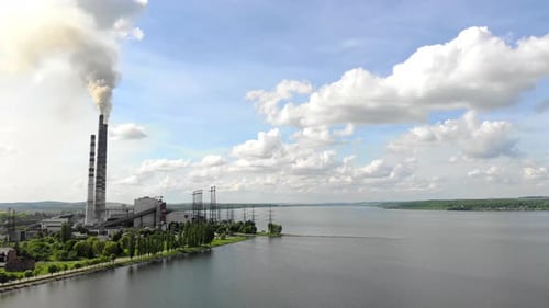 Starker schwarzer Rauch, der aus den Rohren der Wärmestation gegen den blauen Himmel kommt