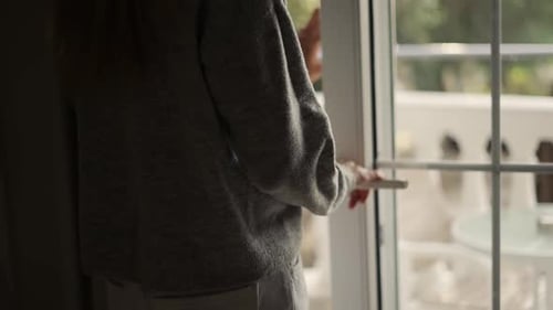 Woman Closing Curtains and Terrace Doors in Hotel Room