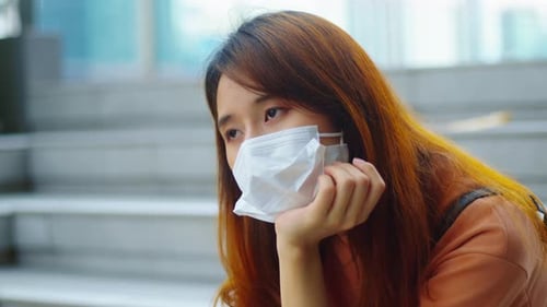 Young asian woman wear medical mask fell bored, stress and loneliness during virus pandemic