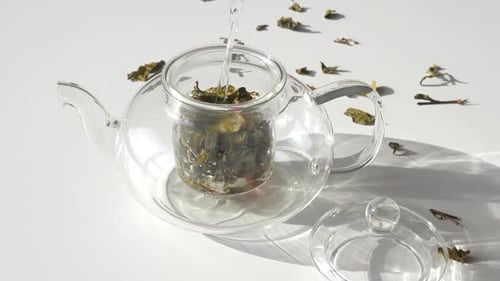 Pouring Water Into Glass Teapot with Tea