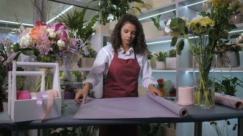 Woman Cutting Wrapping Paper in Flower Shop