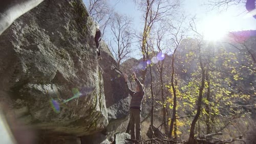 Adults Rock Climbing in Sunny Mountain Landscape
