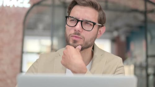 Close Up of Man Thinking While Working on Laptop