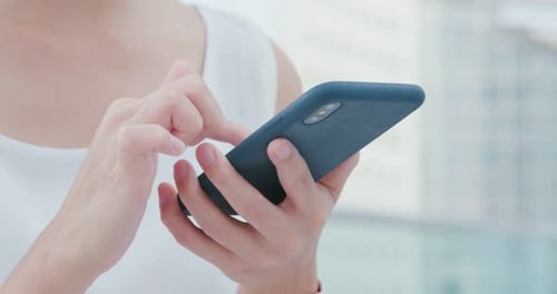 Hands Using Smartphone in Modern Urban Setting