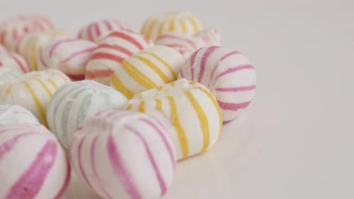 Lot of traditional round sugar candies on white close-up 4K panning video