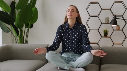 женщина сидит со скрещенными ногами с закрытыми глазами