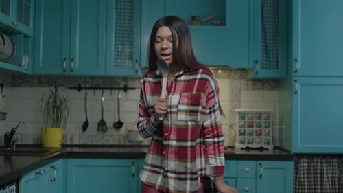 Woman Sings and Dances with Spoon in Kitchen