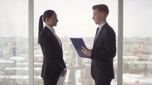Businesswoman and Businessman in Formalwear Discussing Work