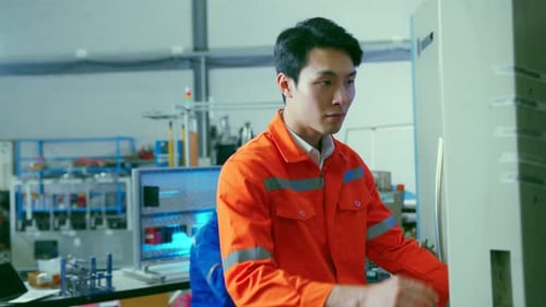 Male Asian engineer professional hand control machine screen in the factory