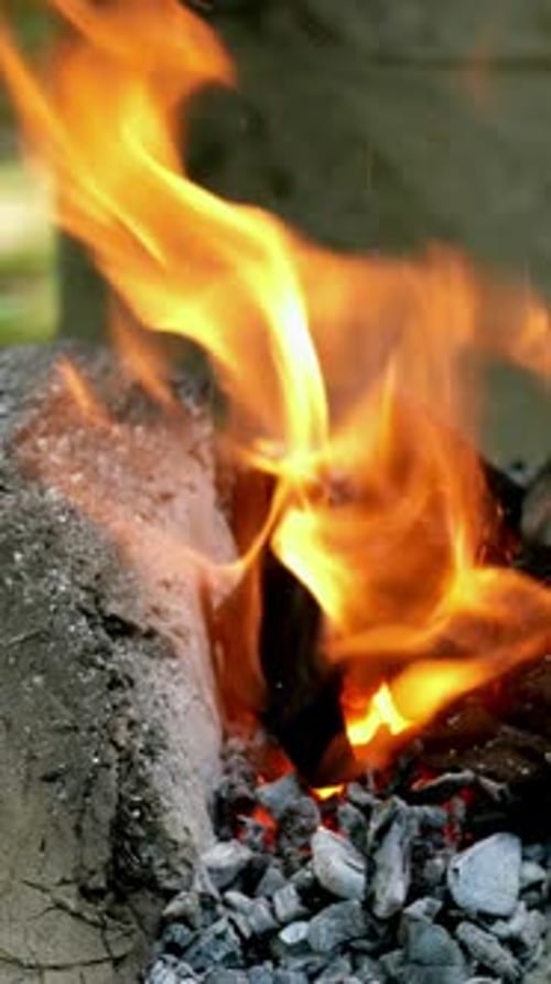 Blacksmith is Engaged in the Manufacture of Metal Products in Mobile Mini Forge Outdoors