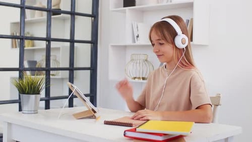 Girl Using Tablet with Headphones for Online Education