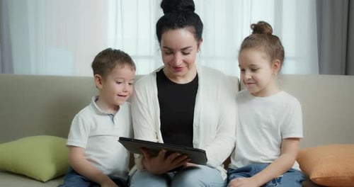 Mother and Children Watching Tablet Together at Home