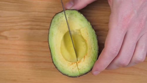 Hands Slice Open a Fresh Avocado