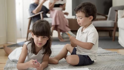Children Drawing Together on Rug at Home
