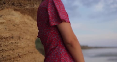 Pretty Woman in Summer Dress Near Big Stone on the Beach