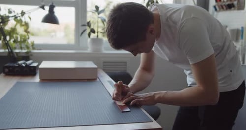 Tanner Transfers the Design To a Leather Belt Using an Awl and a Paper Template