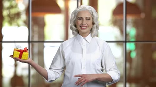 Smiling Woman with Gift Pointing Right