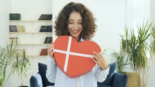 Woman Embraces Heart-Shaped Gift Box with Love