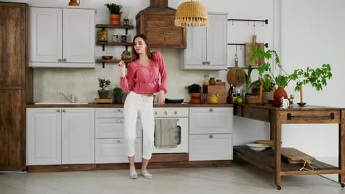 Woman Dancing Energetically in Modern Kitchen