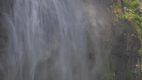 Wunderbare große Wasserfallströme fallen auf Brown Rocky Cliff
