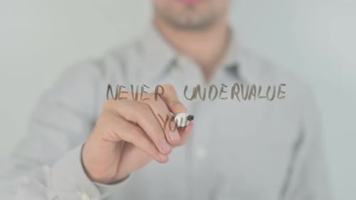 Hand Writing Never Undervalue Yourself on Clear Surface
