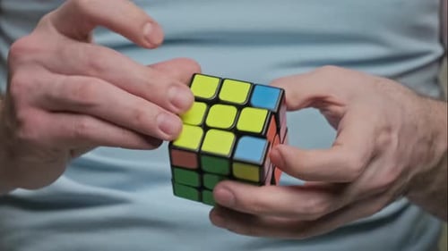 Man Hands Solving Rubik's Cube Puzzle. Puzzle Game.