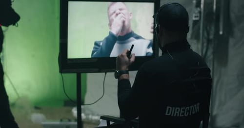 El director da instrucciones y observa la escena en el monitor
