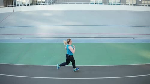Drone View of Overweight Woman Running Along Track