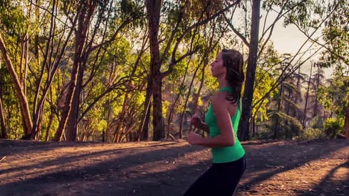Woman Jogging Through Park During Golden Hour