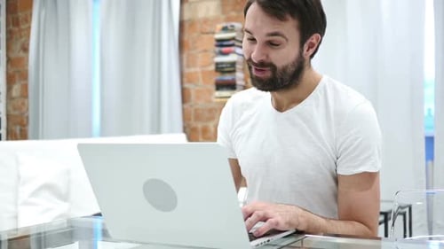 Bearded Man Video Chatting on Laptop