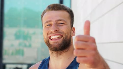 Man Gives Thumbs Up and Smiles