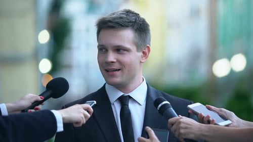 Man Giving Press Conference with Microphones and Recorders