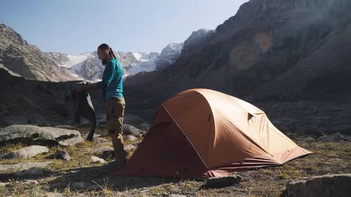 Hiker Tourist with Backpack Walking Near Mountain Lake