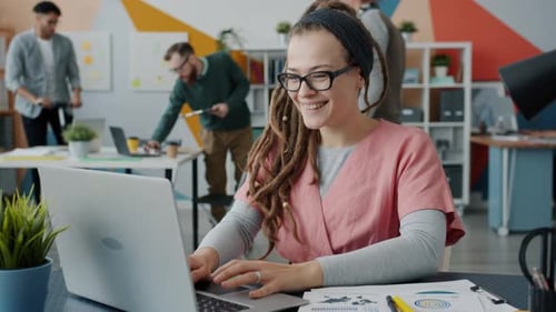 Happy Woman Working on Laptop in Modern Office
