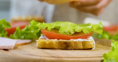 Delicious Sandwich Preparation on a Wooden Board